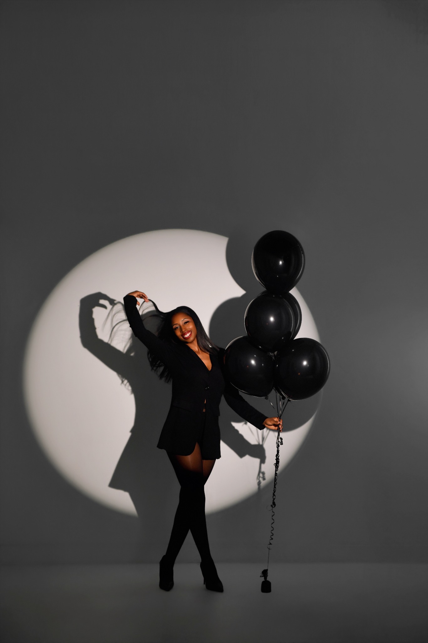 Women’s empowerment portrait with black balloons and dramatic lighting