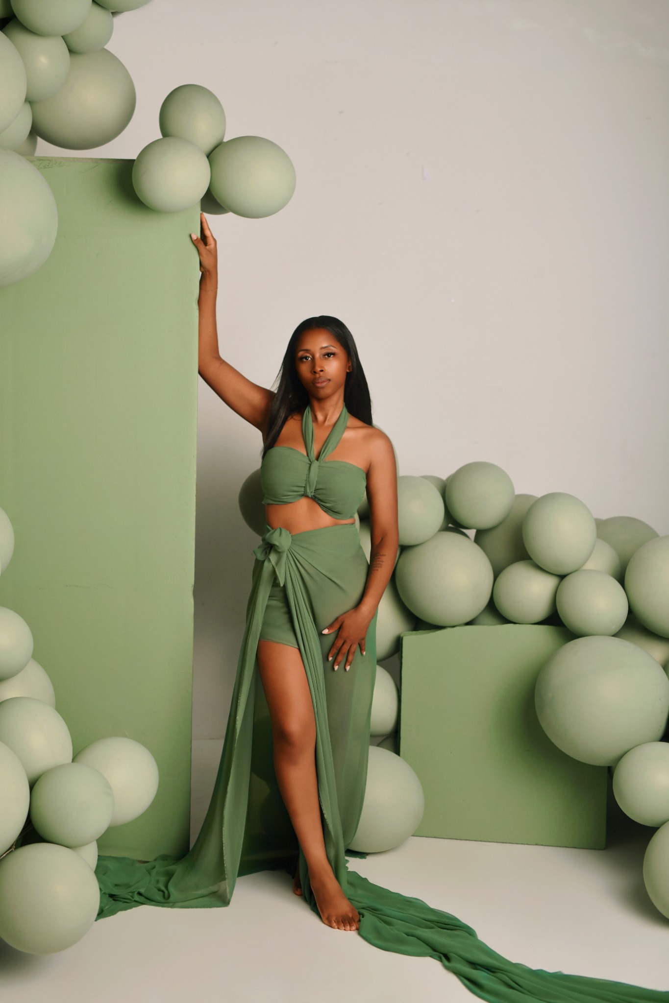 Woman posed against an elegant sage-green studio backdrop